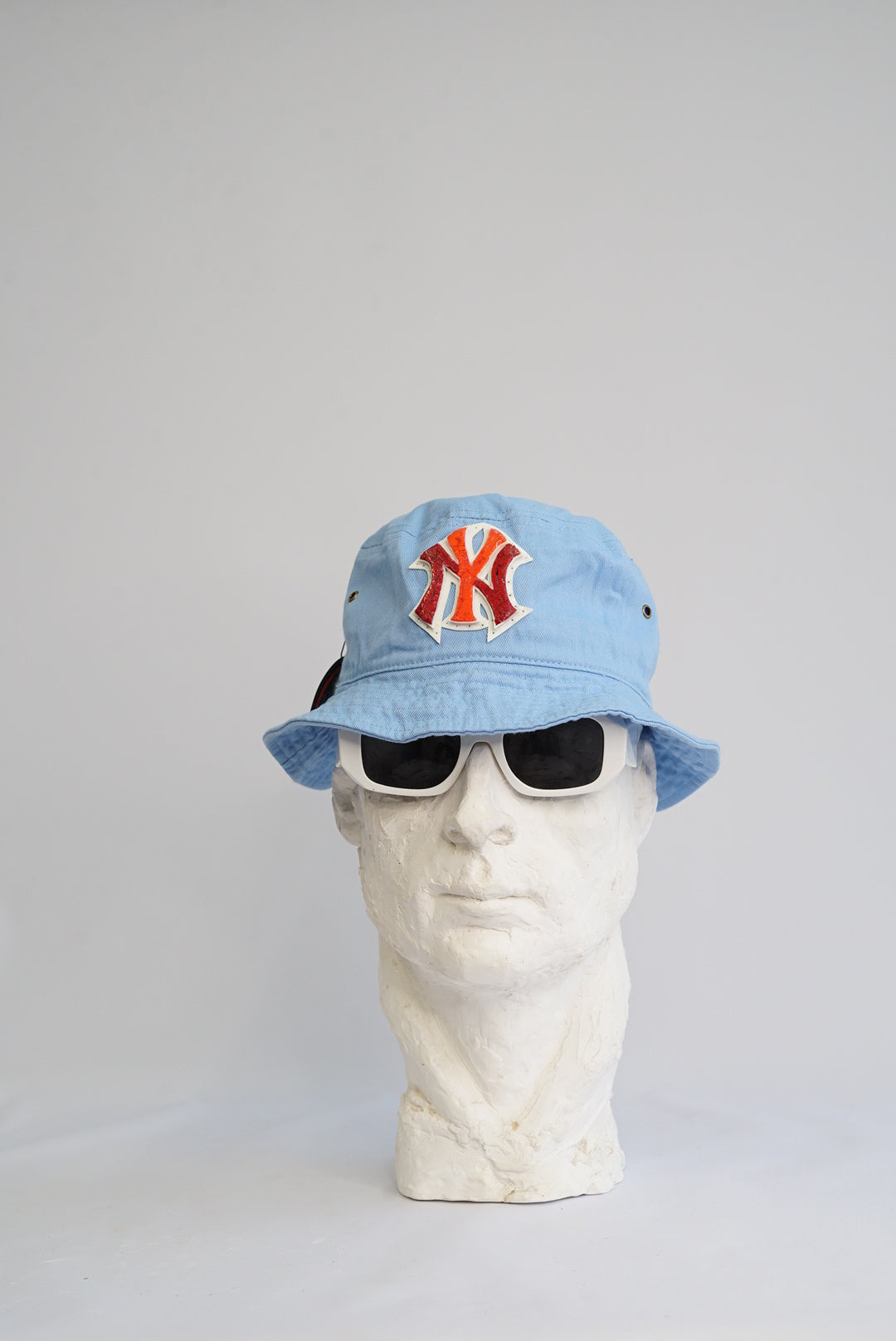 baby blue bucket hat with a red and orange yankees logo