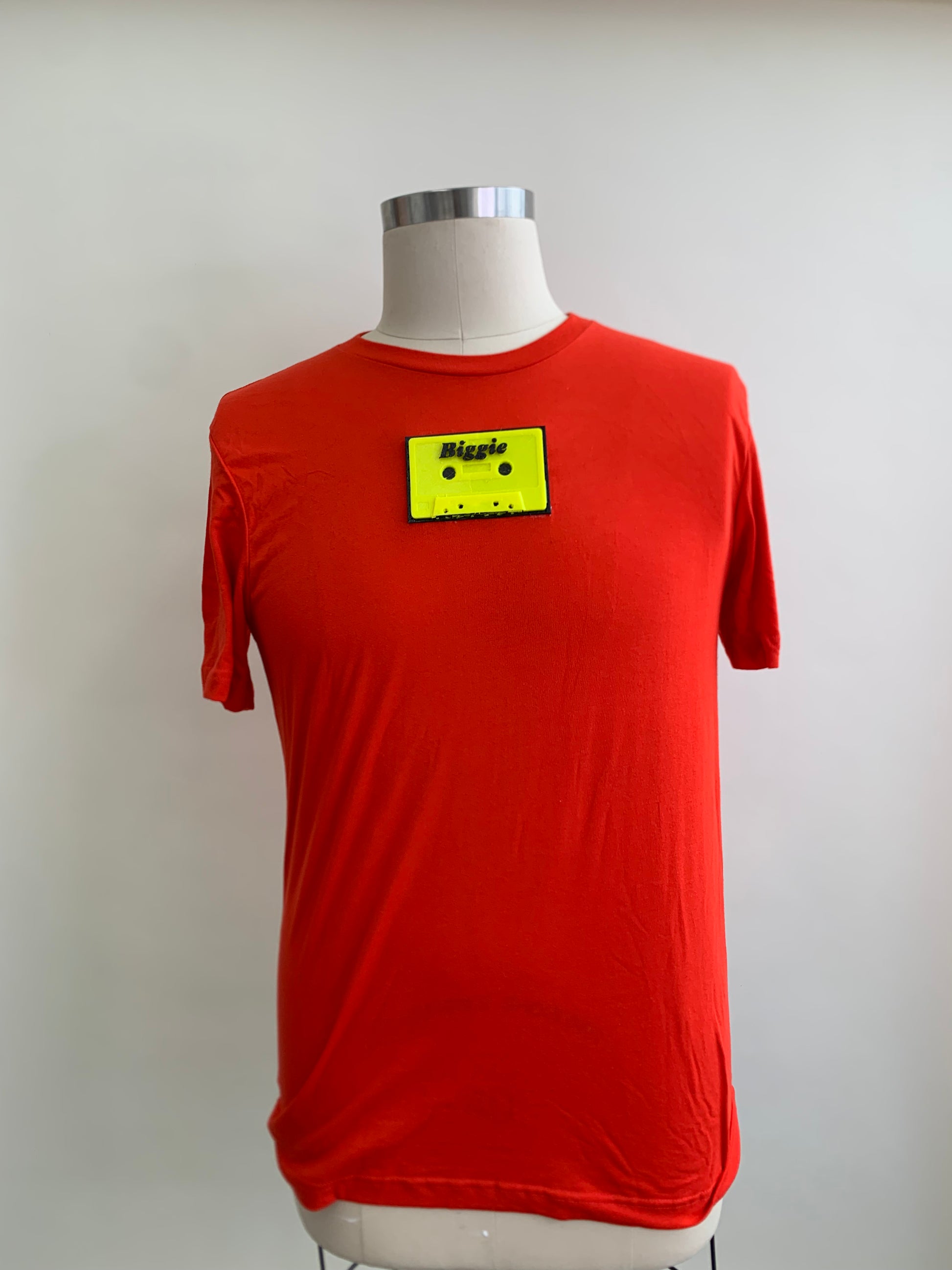 red/orange shirt with a biggie  fluorescent yellow  cassette on chest