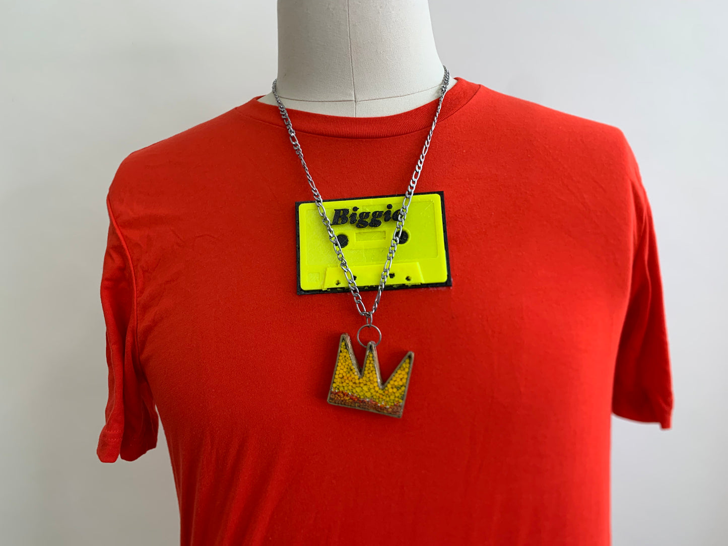red/orange shirt with a biggie  fluorescent yellow  cassette on chest with biggie crown necklace