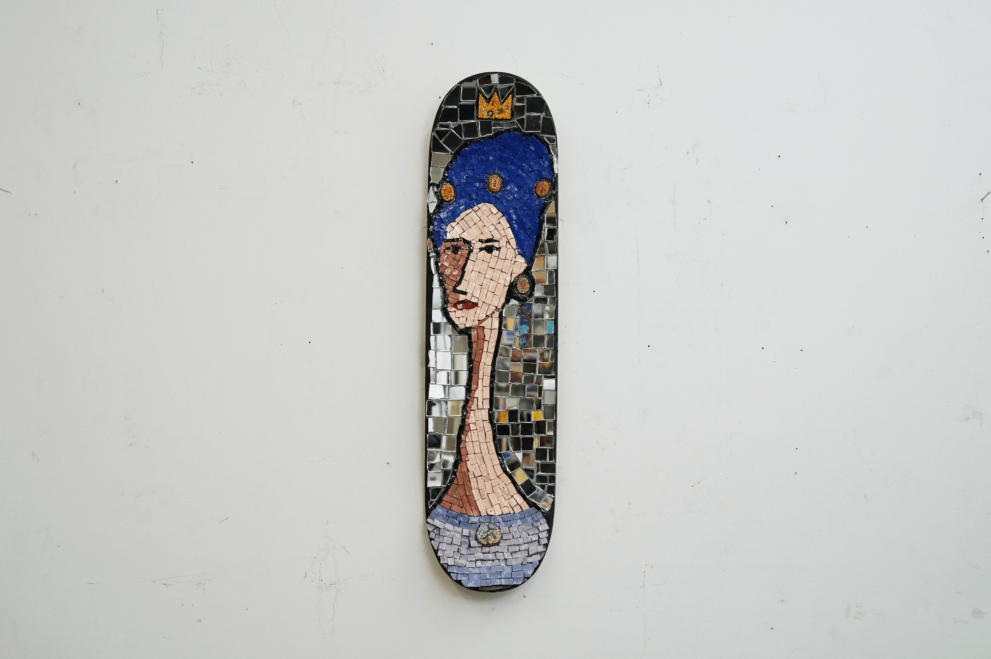 mosaic on a skateboard with blue hair and jewels