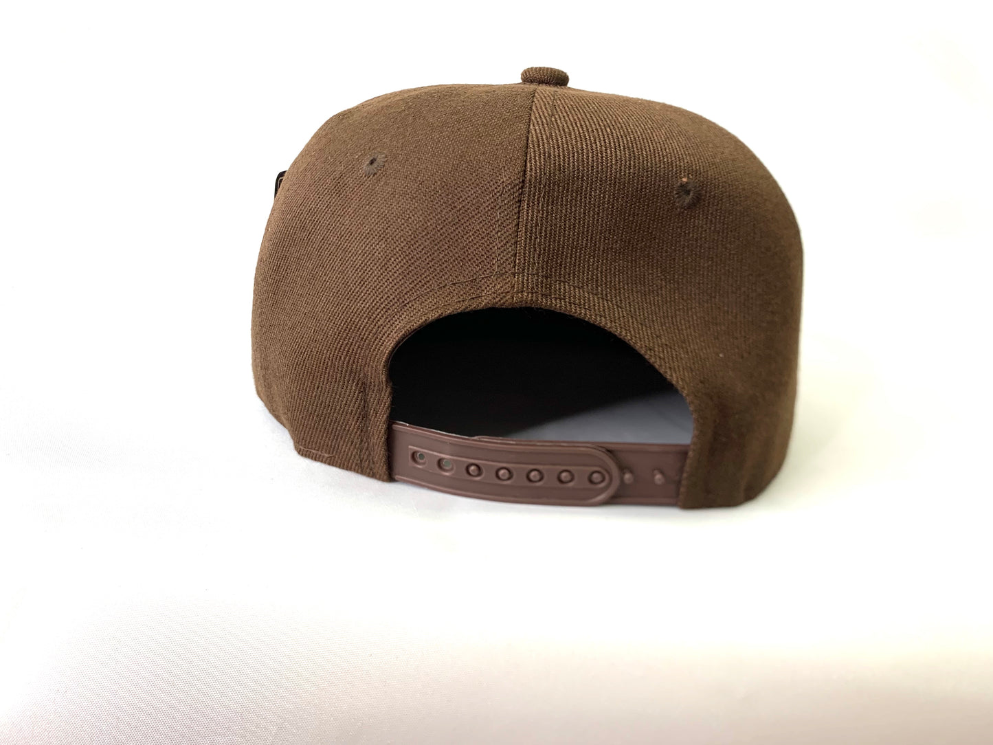 brown baseball hat with a 18 karat gold crown. back view