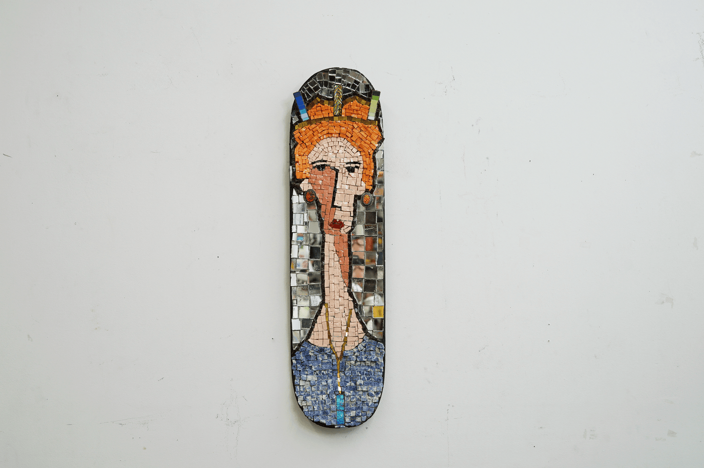 mosaic on a skateboard of a red hair woman with a crown and jewels