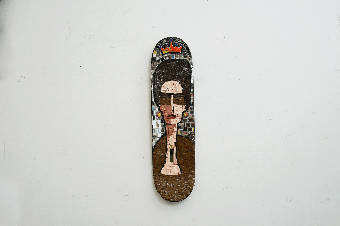 decorative mosaic on a skateboard deck of Slim Keith of a sophisticated woman with jewelry , big hair and sunglasses