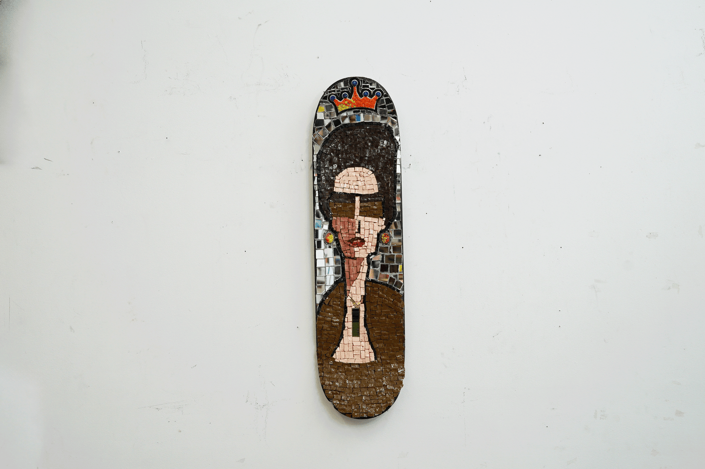 mosaic on a skateboard of a sophisticated woman with jewelry , big hair and sunglasses