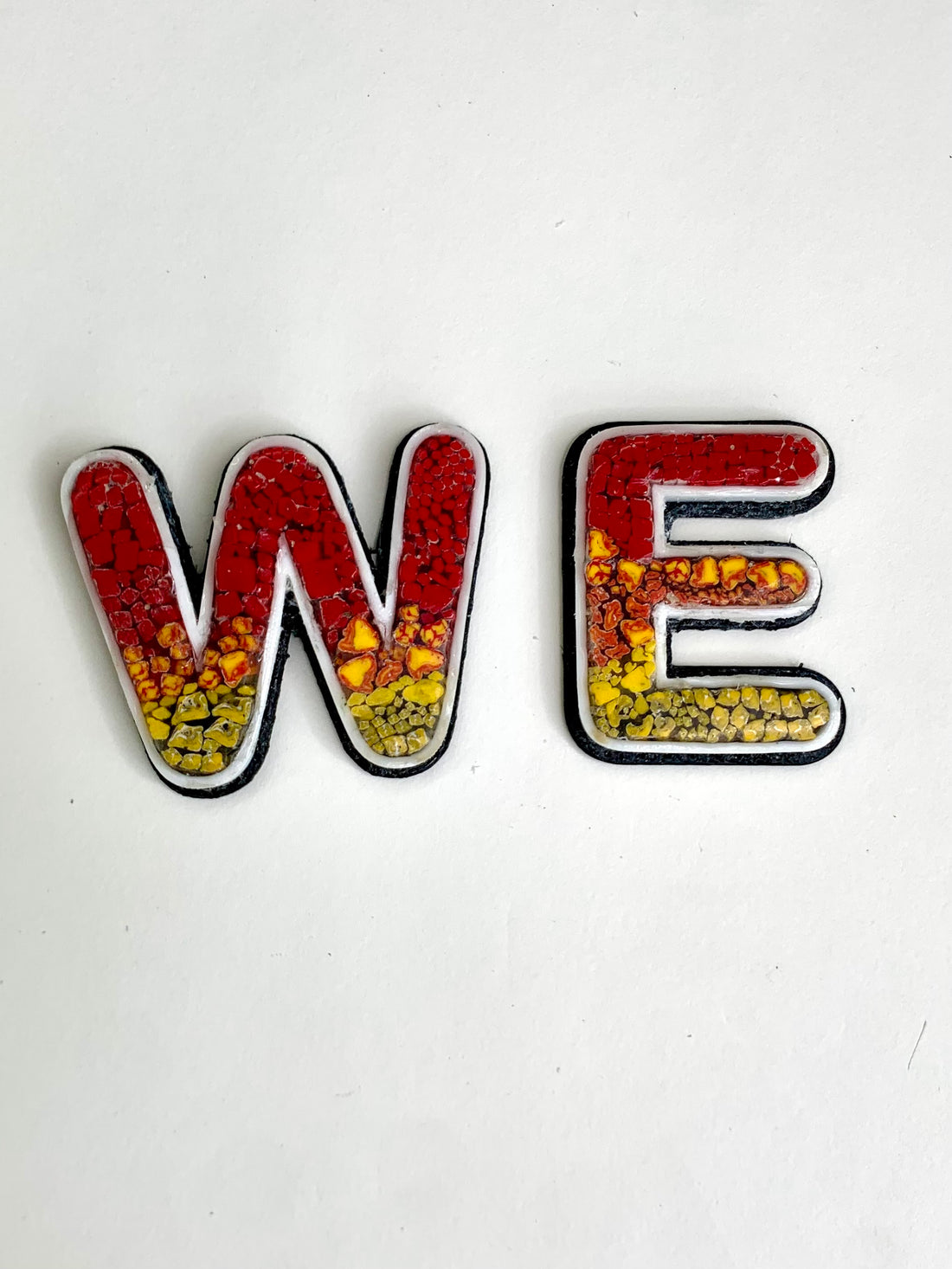 letters w and E with micro mosaic in yellow and orange