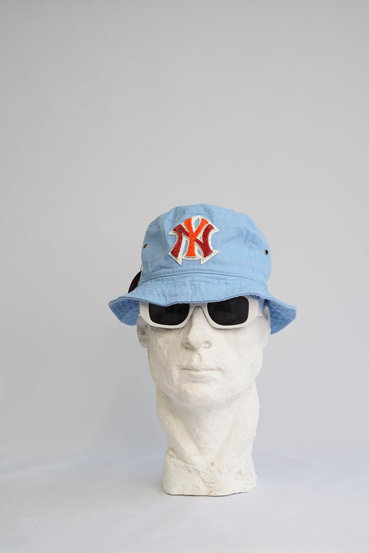 baby blue bucket hat with a red and orange  yankees logo