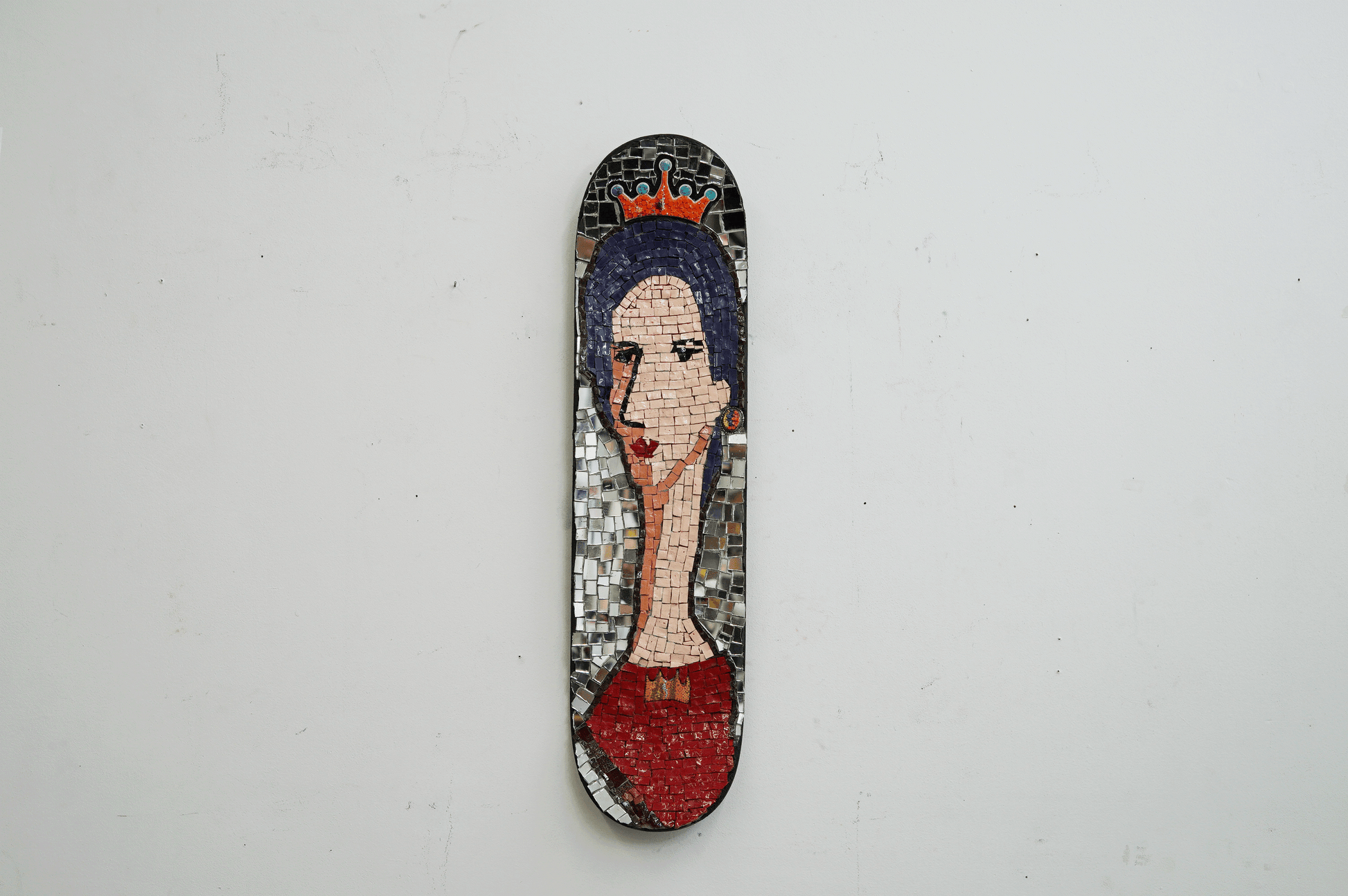 decorative skateboard mosaic portrait of a woman with elongated face with a orange crown and red dress