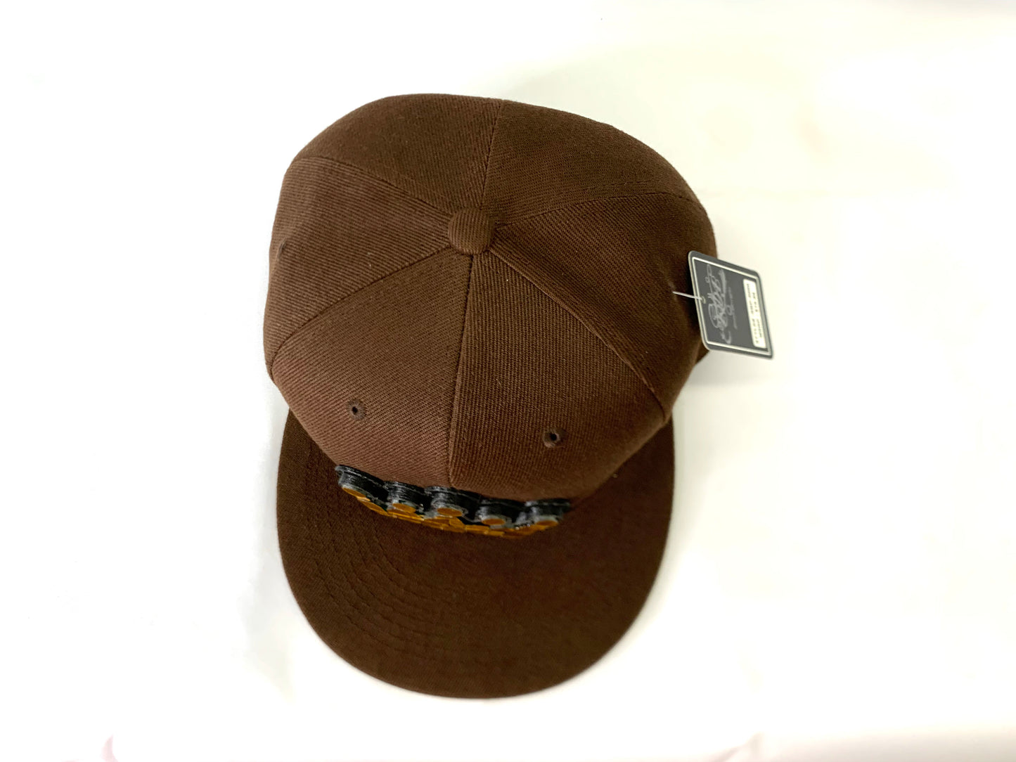 brown baseball hat with a 18 karat gold crown